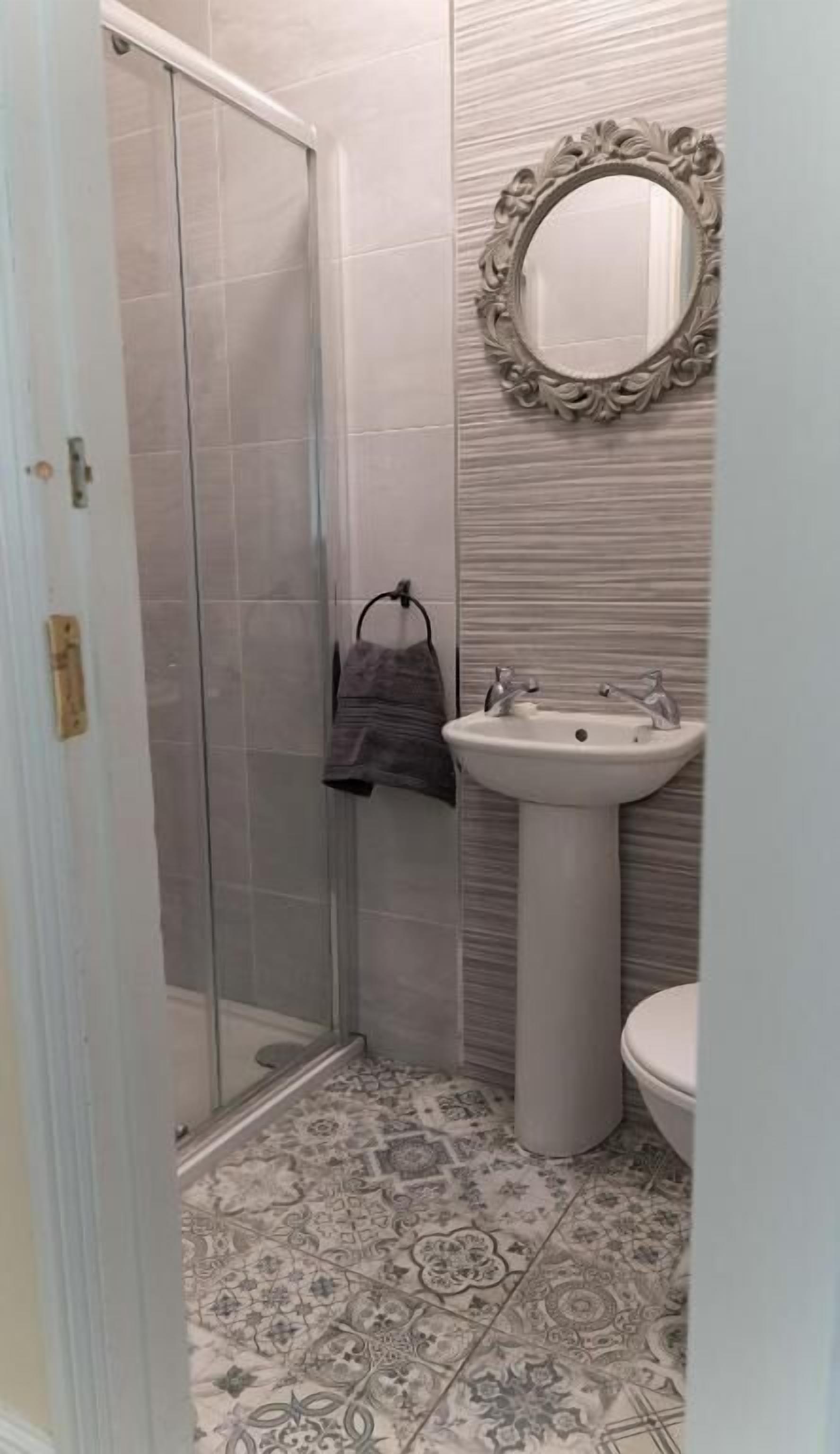 Un baño con ducha, lavamanos e inodoro.