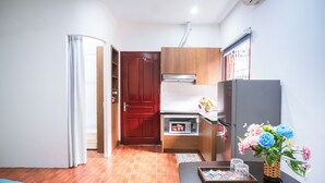 Una cocina compacta con refrigerador, microondas y muebles de madera.