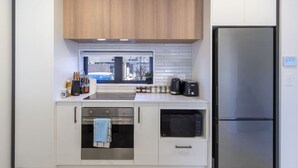 Una cocina moderna con horno integrado, microondas y refrigerador de acero inoxidable.