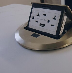 Tira-cabo com várias tomadas e portas USB em base metálica.