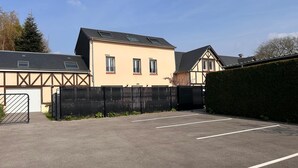 Een parkeerplaats met een gebouw dat een puntige dakschild heeft en een garagepoort.
