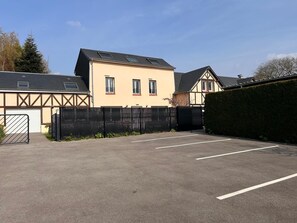 Ein Parkplatz mit einem Gebäude, das ein Satteldach und eine Garagentür hat.