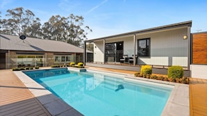 A modern house with a swimming pool, a covered patio, and a view of trees. - Route 86 Bright stunning holiday home with private pool. (Bright)