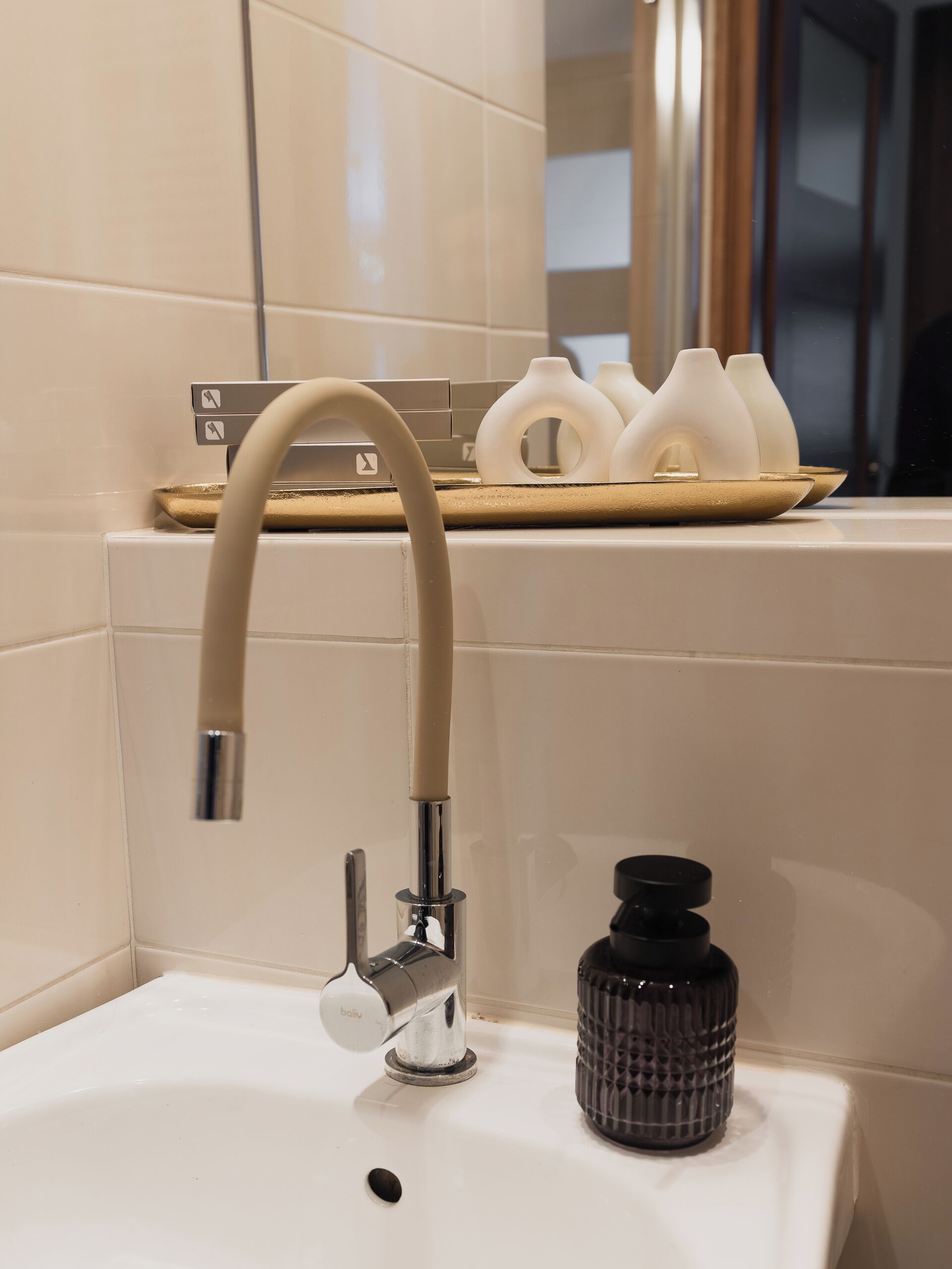 A bathroom with a modern sink, a chrome faucet, and a mirror above the sink.