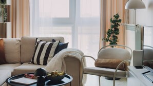 Ett modernt vardagsrum med en soffa, fåtölj, soffbord och en växt.