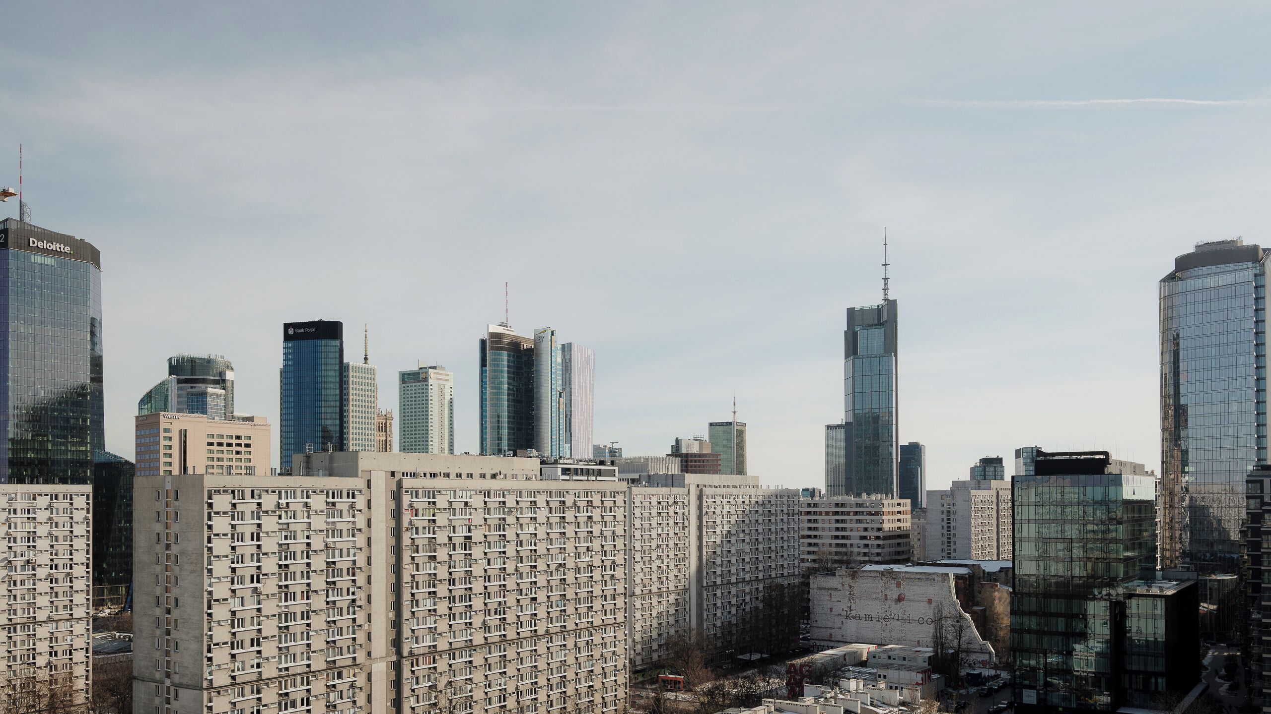A cityscape with high-rise buildings, including a prominent tower with a spire.