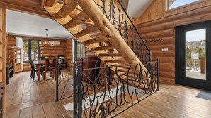 Ein Holzinterieur mit einer Wendeltreppe, einem Essbereich und einem großen Fenster mit Aussicht.