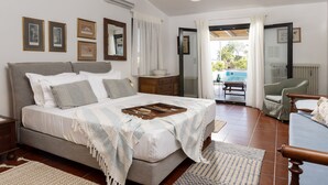 Ein Schlafzimmer mit Bett, Schminktisch, Spiegel und Blick ins Freie.