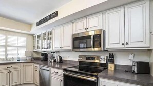A kitchen with white cabinetry, stainless steel appliances, and a 'FREEDOM RING' sign. - Chapel Gate 3BR Steps to City Dock & Naval Academy (Annapolis)