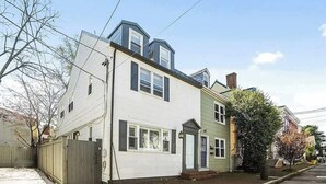 A two-story residential building with a garage, a front door, and a small front yard. - Chapel Gate 3BR Steps to City Dock & Naval Academy (Annapolis)