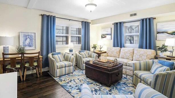 A living room with a dining table, two sofas, a coffee table, and a patterned rug. - Chapel Gate 3BR Steps to City Dock & Naval Academy (Annapolis)