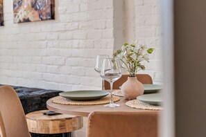 Ein Esstisch mit Tellern, einer Blumenvase und Weingläsern.