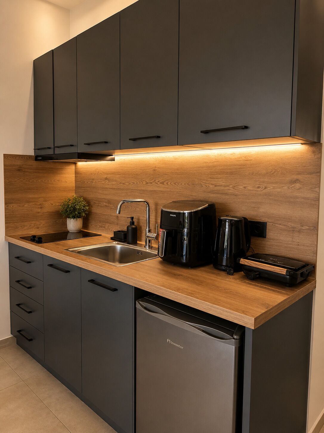 A modern kitchen with dark cabinets, a wooden countertop, a sink, a coffee maker, and a dishwasher.