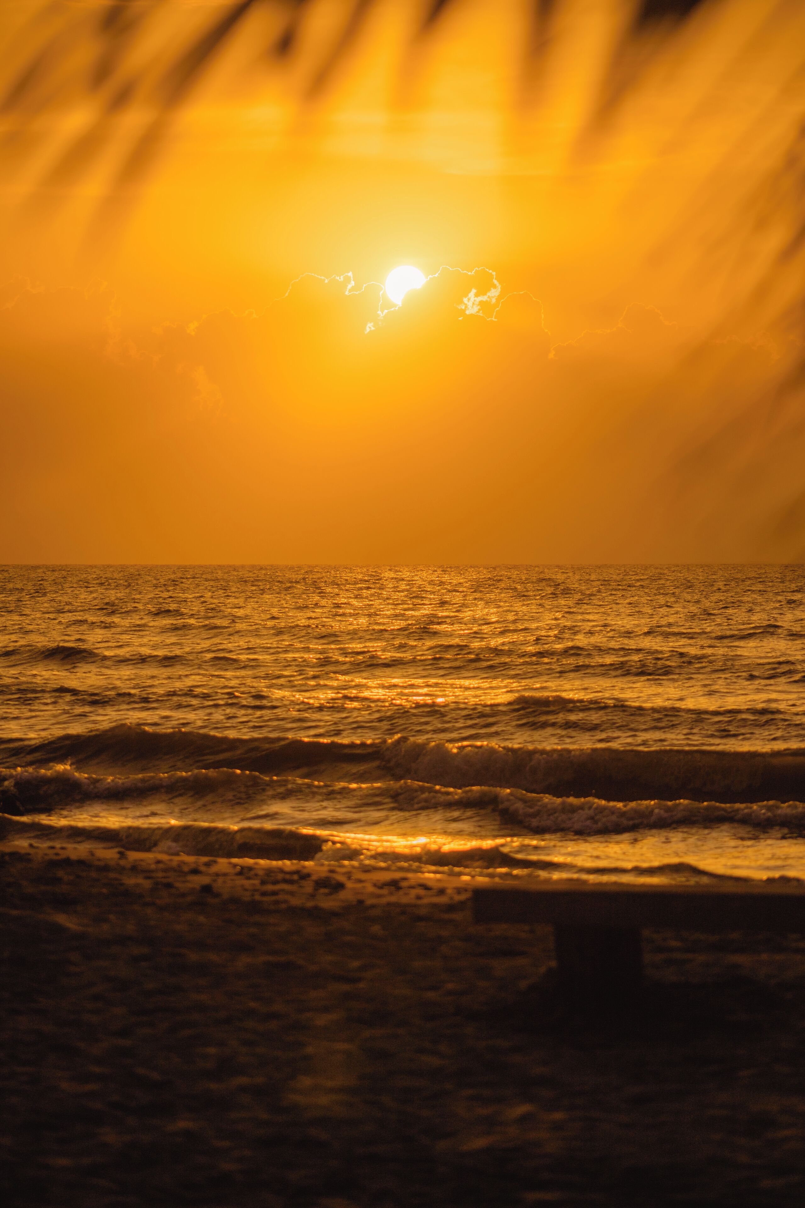 A sunset over the ocean with waves.