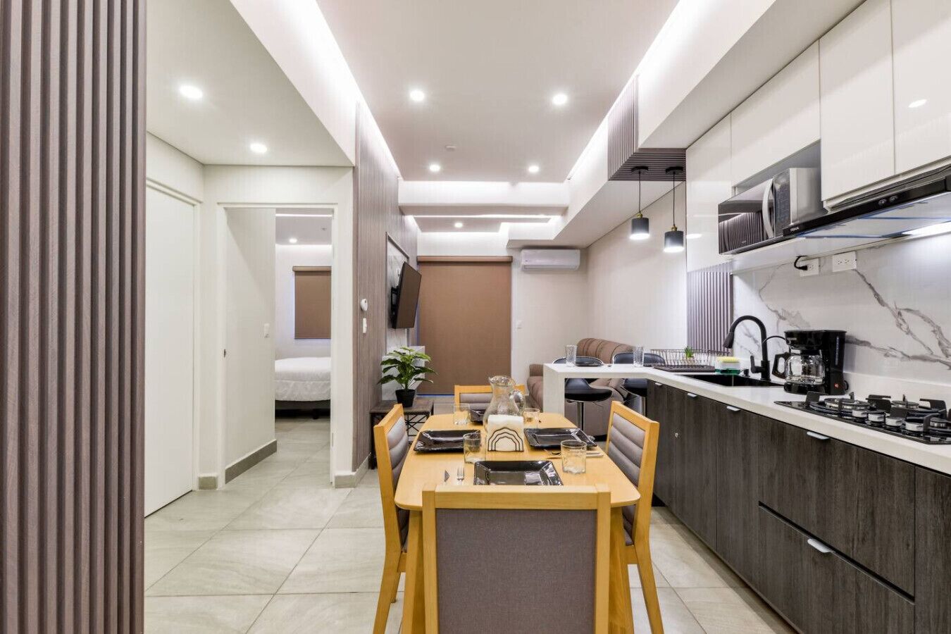 A modern kitchen with a dining area, a microwave, and a coffee maker.