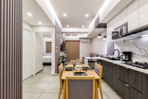 A modern kitchen with a dining area, a microwave, and a coffee maker.
