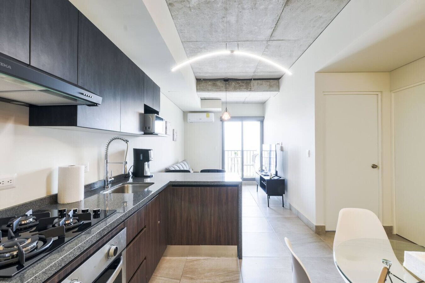 A modern kitchen with dark cabinets, a gas stove, and a central island.