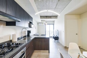 Cocina moderna con armarios oscuros, estufa a gas y una isla central.