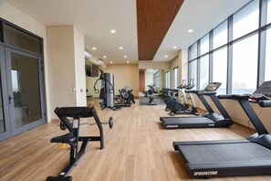 Un gimnasio con cintas de correr, elípticas y máquinas de pesas.