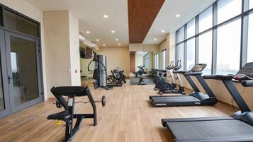A gym with treadmills, elliptical machines, and weight equipment.