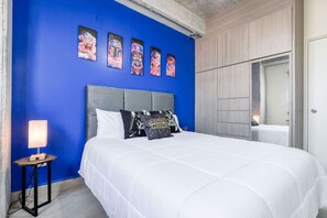 A bedroom with a blue wall, a grey headboard, white bedding, and Star Wars themed pillows. - ¡Céntrico & Nuevo! 1 Queen Bed + Double Sofa Bed (Monterrey)