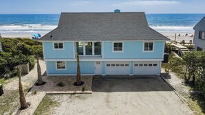 A two-story house with a garage, located near a beach with ocean views.