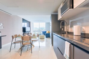 A modern kitchen with a dining area, a large window, and a view of the city.