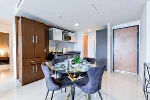 A modern kitchen with built-in appliances, a dining area with a glass table and velvet chairs, and a wooden door. - ¡Luxury in Santa Lucía! Wifi, Gym & Pool 6 guests (Monterrey)