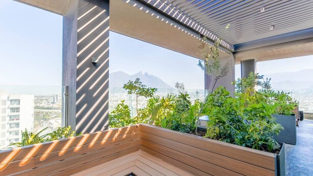 Ein modernes Interieur mit einer hölzernen Bank, großen Fenstern und Blick auf Stadt und Berge.