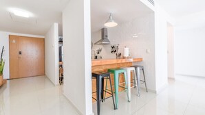 A modern kitchen with a wooden countertop, bar stools, and a hanging light fixture. - ¡A pasos de Santa Lucía! 1 King & 2 Queen Bed 7Ppl (Monterrey)