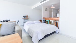 A modern hotel room with a bed, a small seating area, a kitchenette, and a dining table. - ¡A pasos de Santa Lucía! 1 King & 2 Queen Bed 7Ppl (Monterrey)