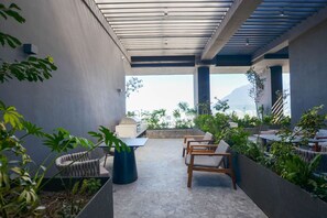 A rooftop terrace with seating, a grill, and a view of the city and mountains. - ¡Loft in Santa Lucía! 3 guests, GYM, Pool, Parking (Monterrey)