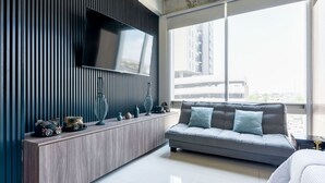 A modern living room with a large TV, a sofa, and a console table with decorative items. - ¡Loft in Santa Lucía! 3 guests, GYM, Pool, Parking (Monterrey)