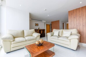 A modern living room with two cream-colored sofas, a wooden coffee table, and a wooden accent wall. - ¡New in Santa Lucía! 6 guests, GYM, Pool, Parking (Monterrey)