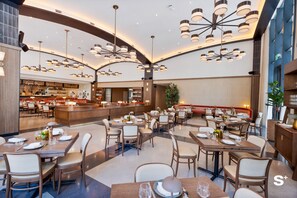 A modern restaurant with multiple dining tables, a bar area, and contemporary lighting fixtures. - Upscale 1BD Condo in Miami- City Views (Miami)