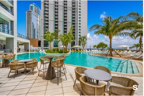 A hotel pool area with lounge chairs, a pool table, and a view of high-rise buildings. - Upscale 1BD Condo in Miami- City Views (Miami)