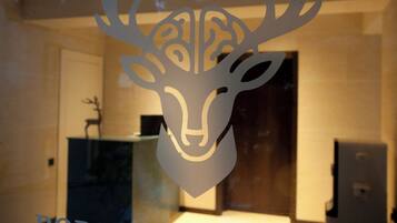 A decorative deer head cutout on a glass window.