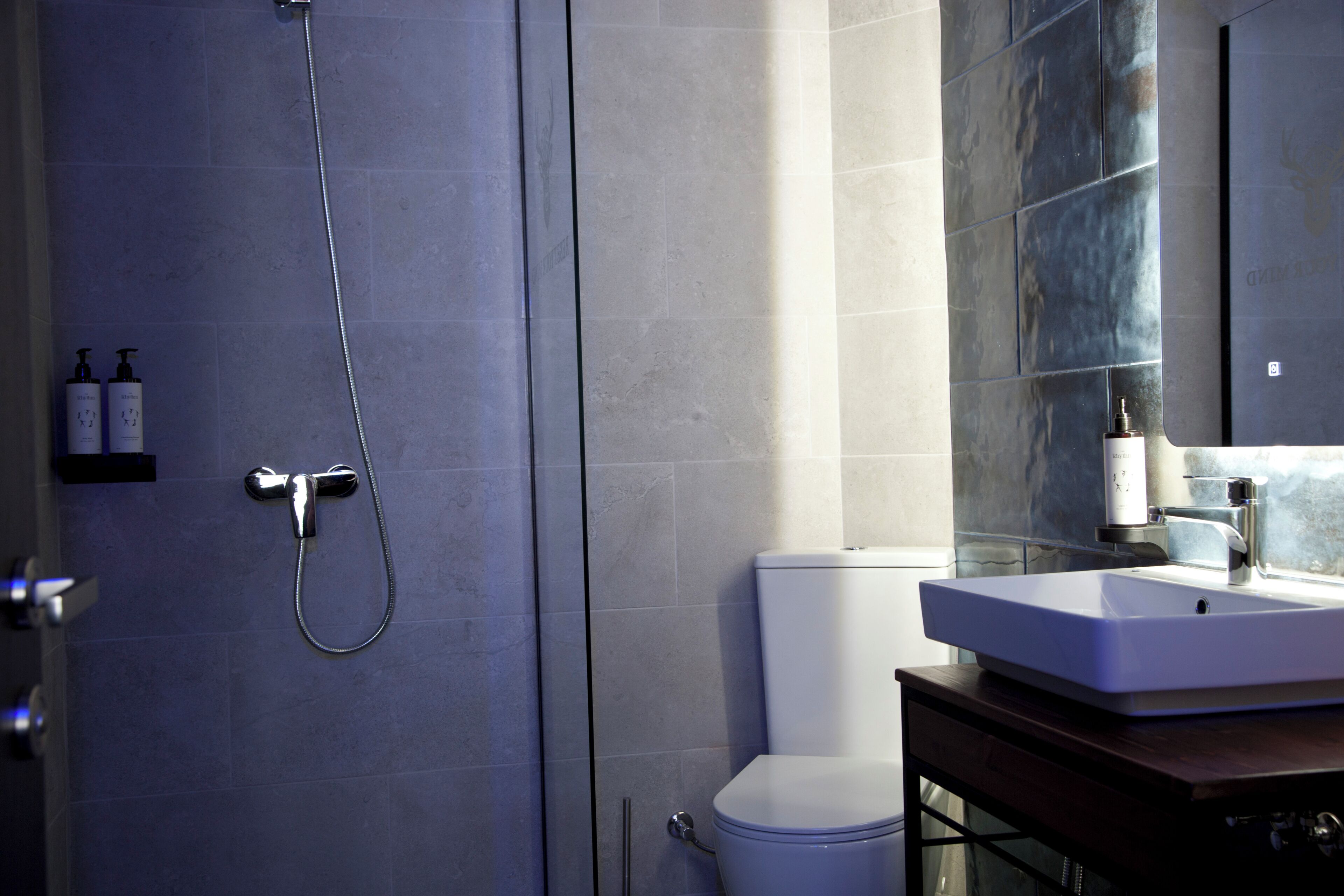 A modern bathroom with a shower, toilet, and sink.