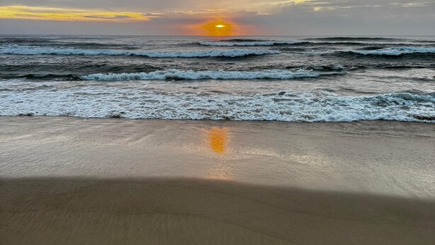 A beach with waves and a sunset. - Pousada Mahara (Imbituba)