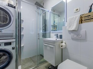 Un bagno moderno con box doccia in vetro, lavandino e water.
