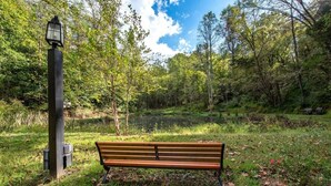 A bench in a park with a lamppost and trees in the background.