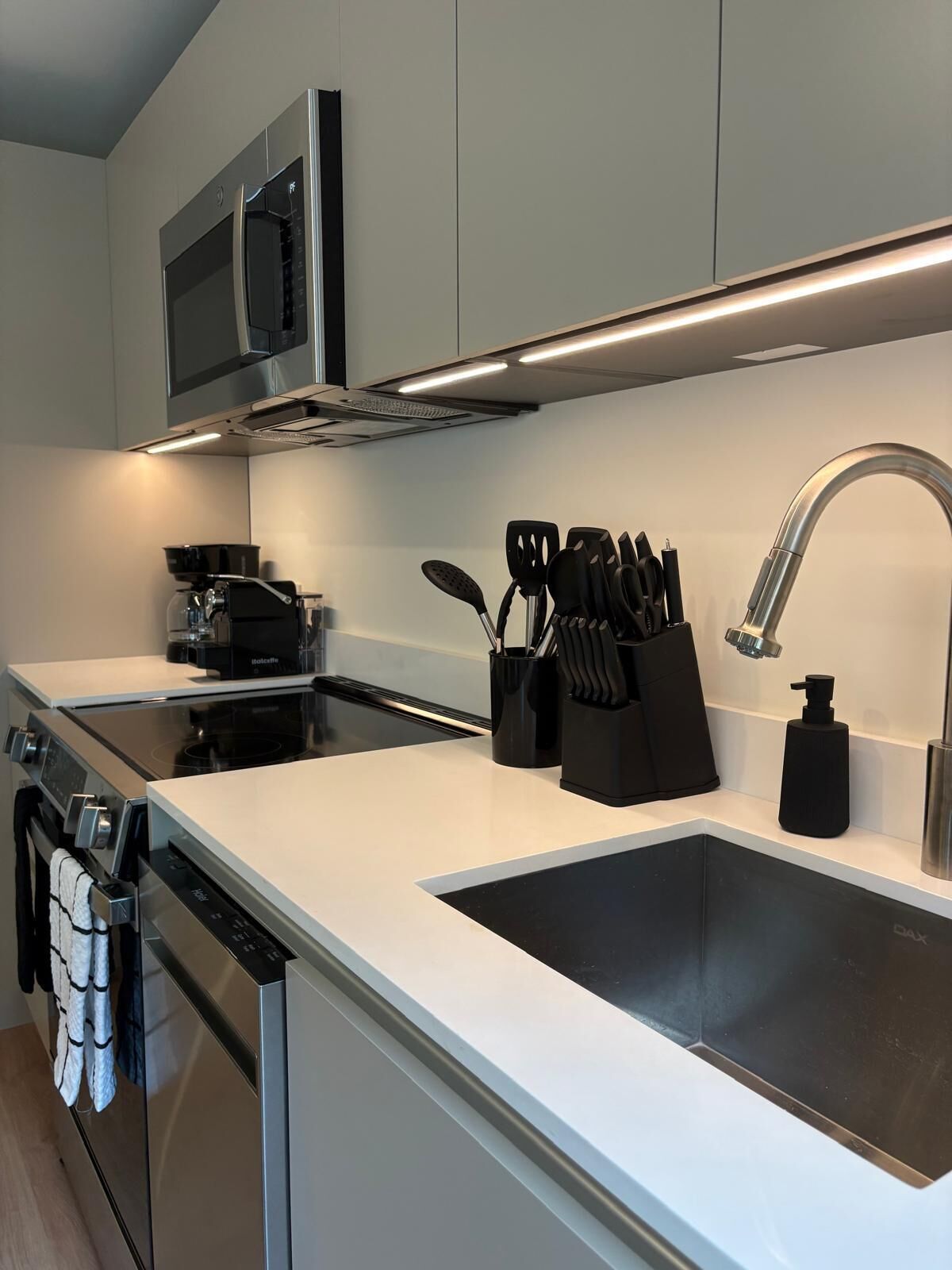 A modern kitchen with stainless steel appliances, a microwave, and a sink.