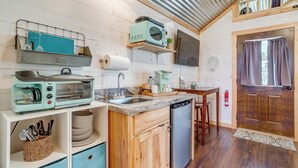A compact kitchen with a microwave, toaster, sink, and a small refrigerator. - Skyview Ranch Family Cabin (Bluff Dale)