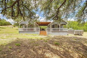 A two-story house with a covered porch, a wooden staircase, and a large tree in the background. - Skyview Ranch Family Cabin Duo (Bluff Dale)