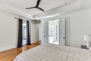 Ein Schlafzimmer mit einem Bett, einem Deckenventilator und Blick auf den Flur.