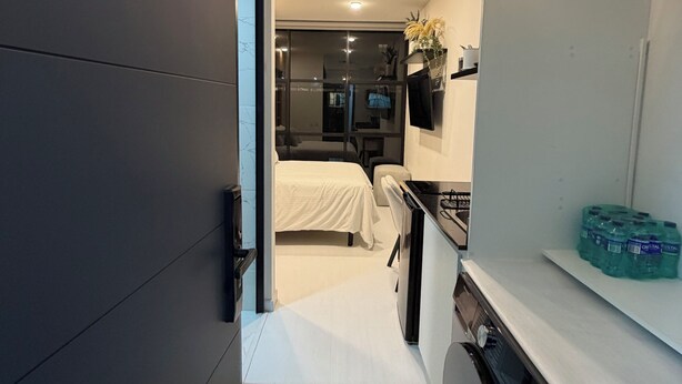 Una camera d'albergo moderna con un letto, angolo cottura e bagno.