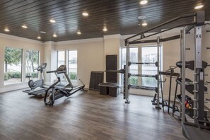 Een sportschool met loopbanden, een rek voor squats en een halterbank.