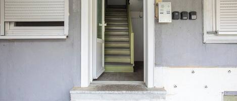 A staircase leading to a door with a security panel and a keypad on the wall.
