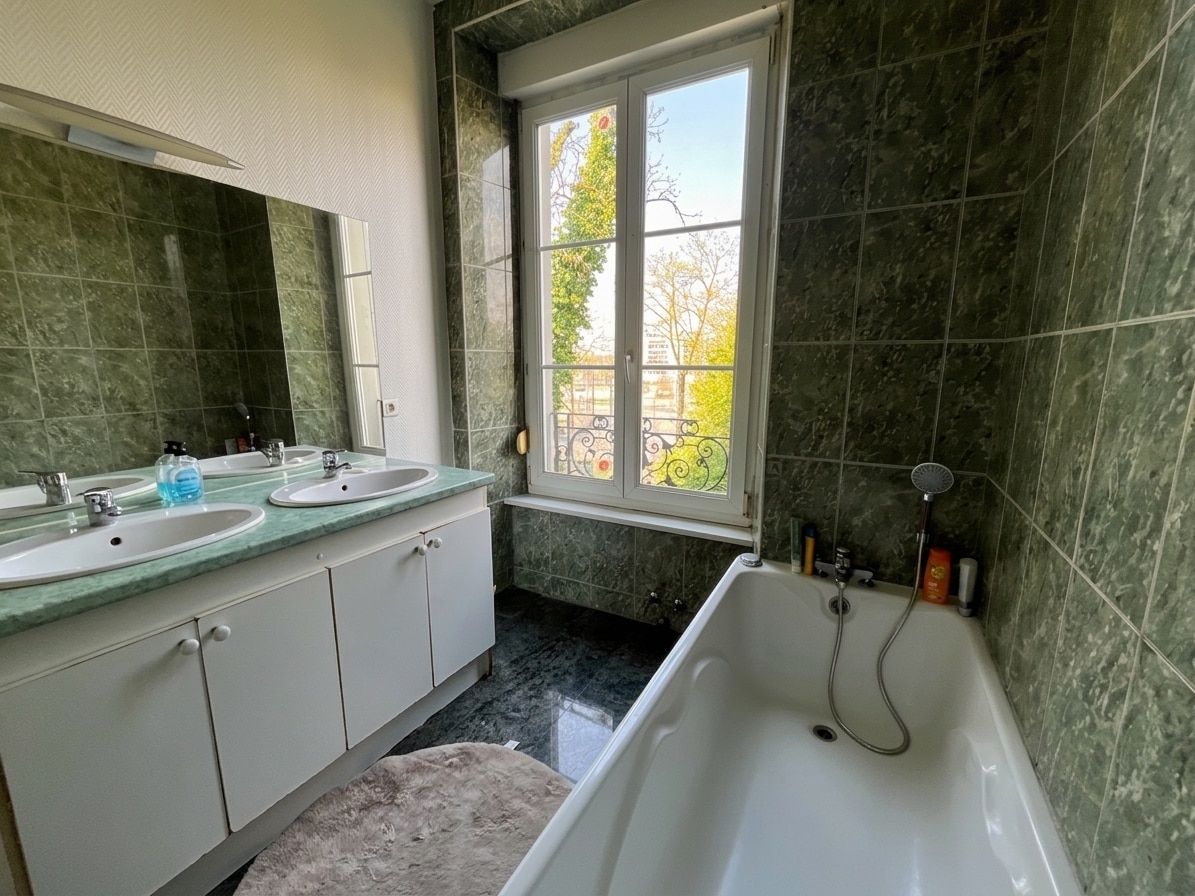 A bathroom with two sinks, a bathtub, and a window with a view.