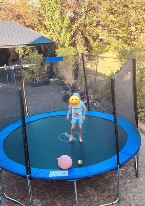 A trampoline with a safety net, surrounded by trees and a fence. - WeserWaldGlück Vacation Rental - "A Little Getaway" - NEW in Wesertal for 4-5 people (Wesertal)